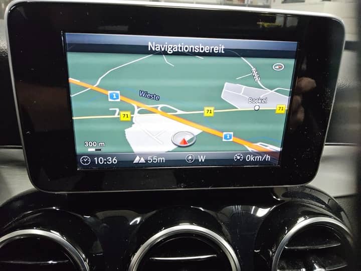 Slika prikazuje unutrašnjost vozila s navigacijskim zaslonom.