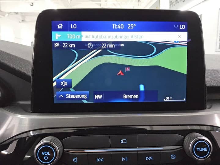 Slika prikazuje unutrašnjost vozila s navigacijskim zaslonom.