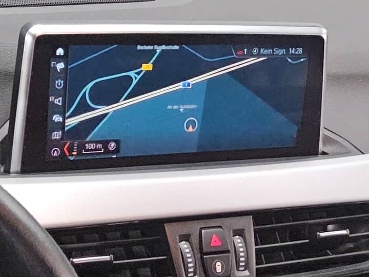 Slika prikazuje unutrašnjost vozila s navigacijom.