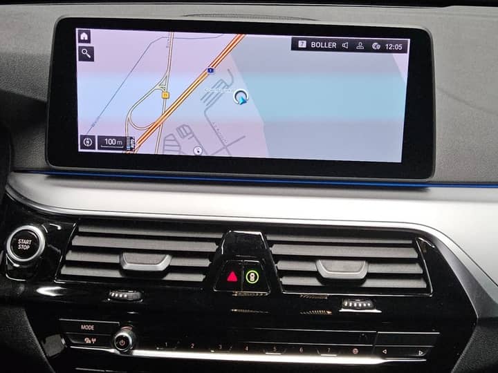 Slika prikazuje unutrašnjost vozila s navigacijskim zaslonom.