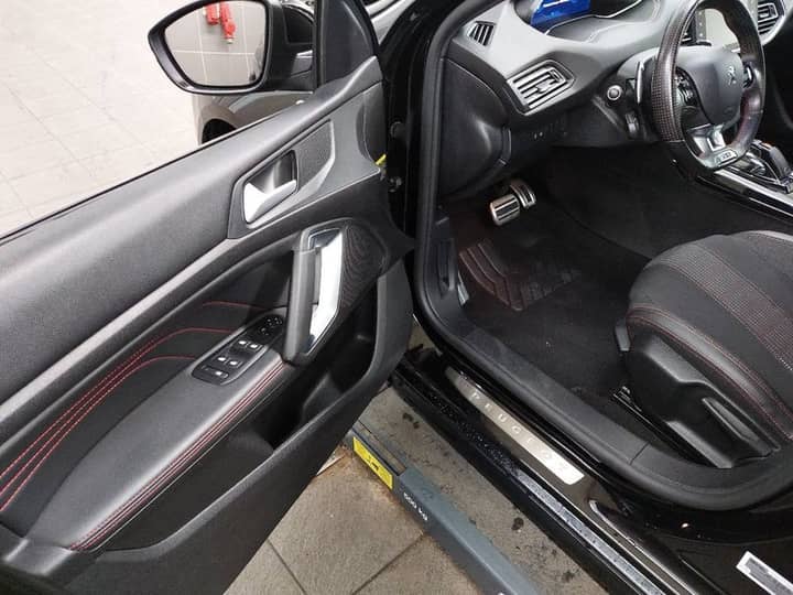 Slika prikazuje unutrašnjost vozila, fokus na volan i sjedala.