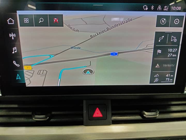 Slika prikazuje unutrašnjost vozila s navigacijskim zaslonom.