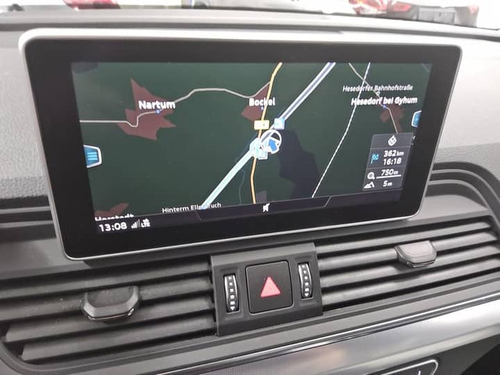 Slika prikazuje unutrašnjost vozila s navigacijskim zaslonom.