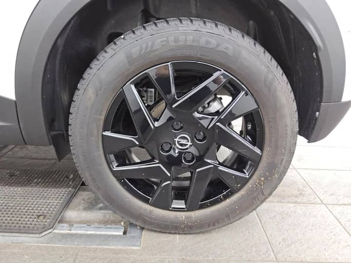 Vanjski kadar automobila: fokus na felgu i gumu uz stražnji lijevi dio karoserije.