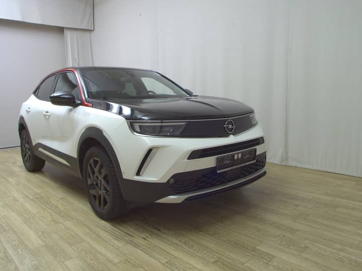 Snimka prikazuje ljubičasti/bijeli SUV vidljiv s prednjeg lijevog boka na parkiralištu.
