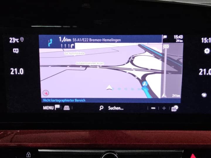 Gledam zaslon s infotainment sustavom automobila, prikazuje navigacijski ekran i dio instrument ploče.