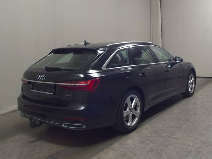 Tamno plavi karavan Audi vidljiv s leđa na zatvorenoj lokaciji, bočni profil i stražnji dio.