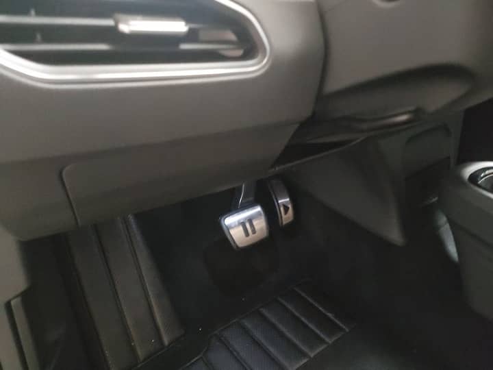 Slika prikazuje unutrašnjost vozila, fokus na pedalama.