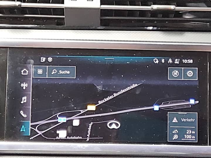 Slika prikazuje unutrašnjost vozila s navigacijskim zaslonom.