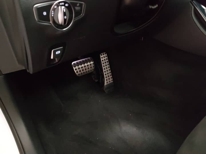 Slika prikazuje unutrašnjost vozila, pedale i pod.