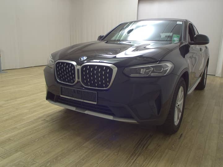 Prednji dio i bočni dio sive limuzine BMW na parketu, prikazuje karoseriju i prednja svjetla.