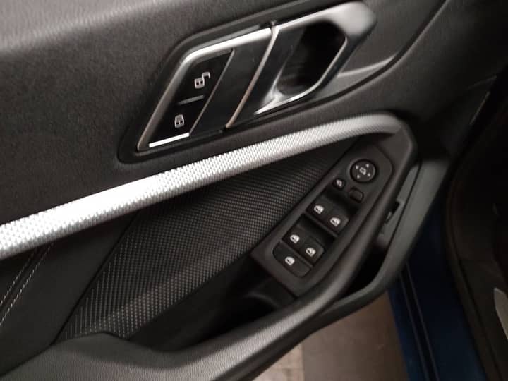 Slika prikazuje unutrašnjost vozila — panel vrata s gumbima.