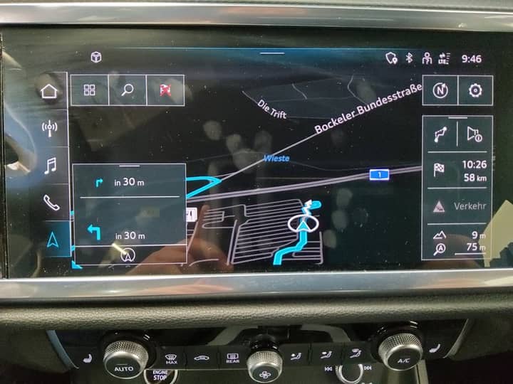 Slika prikazuje unutrašnjost vozila s navigacijskim zaslonom.