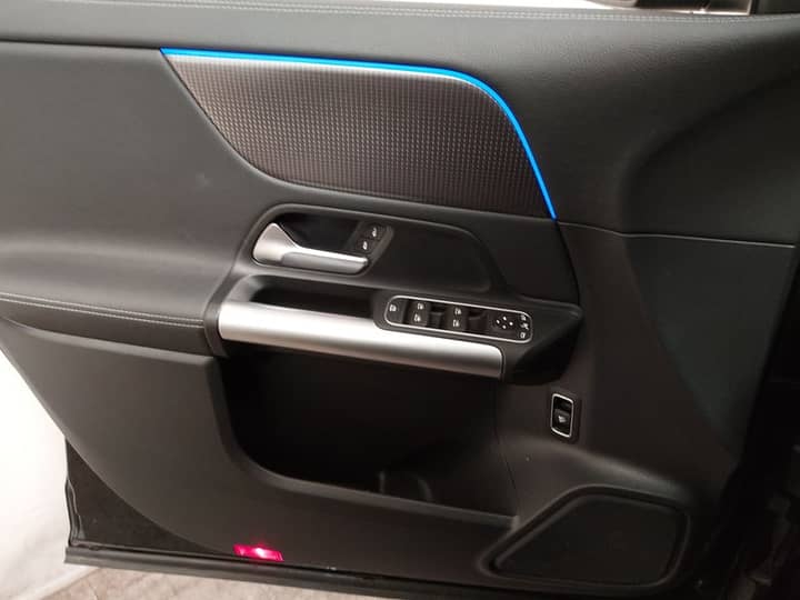 Slika prikazuje unutrašnjost vozila, panel vrata i kontrolne gumbe.