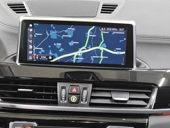 Slika prikazuje unutrašnjost vozila s navigacijskim zaslonom.