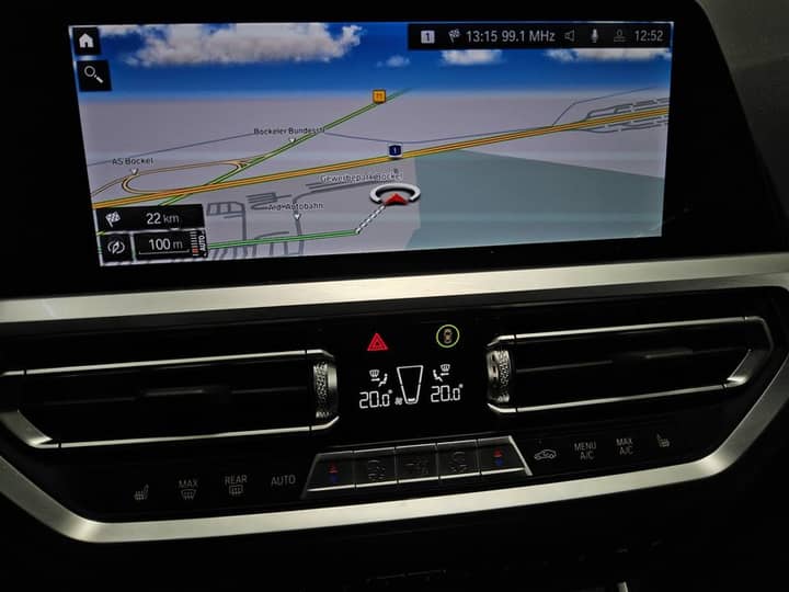 Slika prikazuje unutrašnjost vozila s navigacijskim zaslonom i komandama.