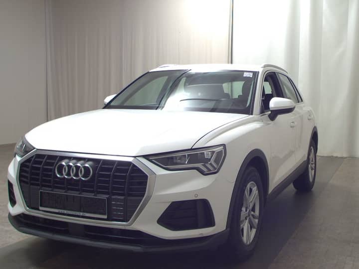 Bijeli SUV Audi na unutrašnjem/vanjskom kadru u radionici, s prednjim lijevim bokom i dijelom cjelokupnog auta.