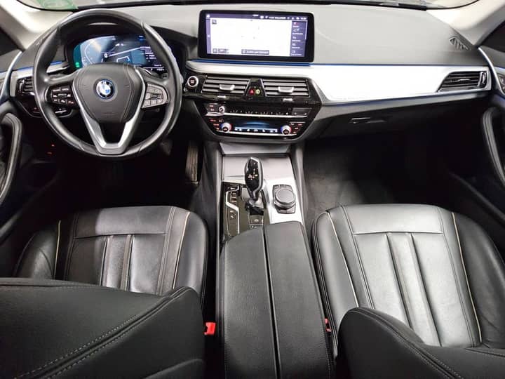 Snimka prikazuje unutrašnjost automobila: volan, središnja konzola i prednje sjedalice.