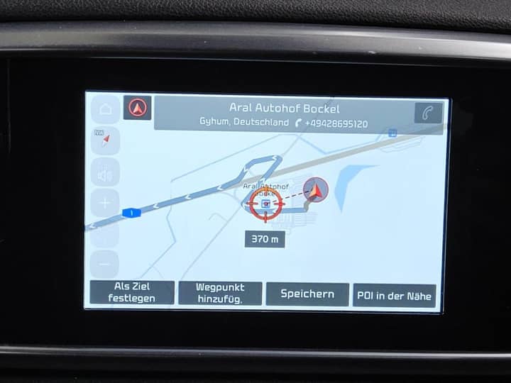Slika prikazuje interijer vozila, fokus na zaslon navigacije.