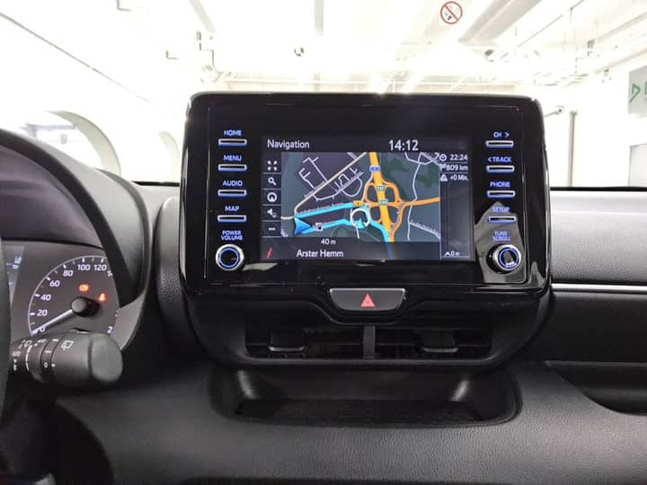 Slika prikazuje unutrašnjost vozila s ekranom navigacije.