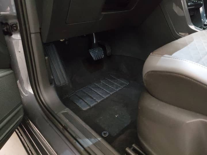 Slika prikazuje unutrašnjost vozila, fokus na pod i pedale.