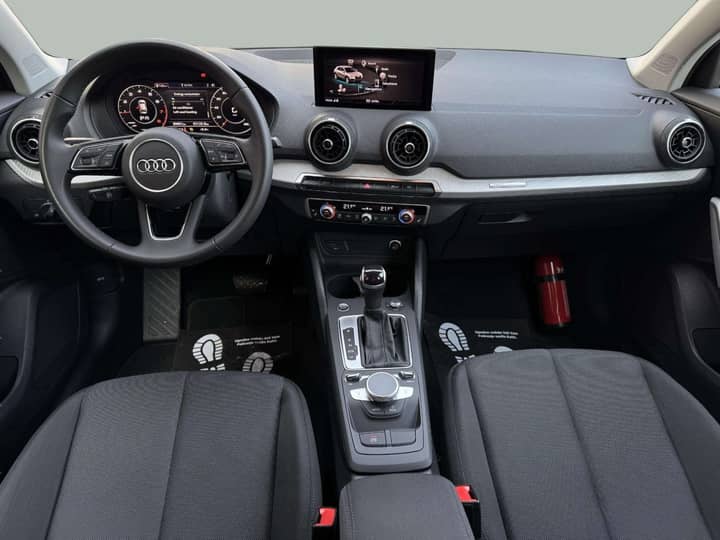 Slika prikazuje unutrašnjost automobila: volan, instrument ploča i središnja konzola.