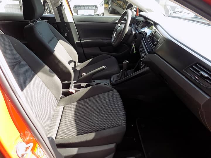 Slika prikazuje unutrašnjost vozila s detaljima sjedenja i volana.