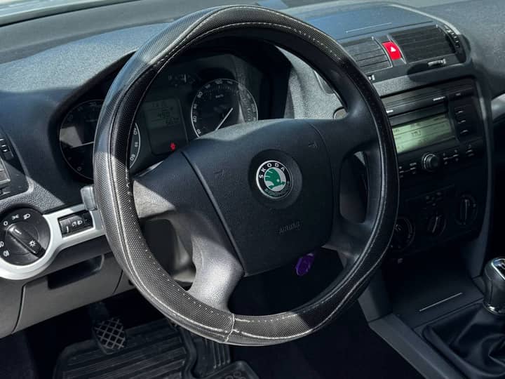 Slika prikazuje unutrašnjost vozila, volan i instrument ploča.