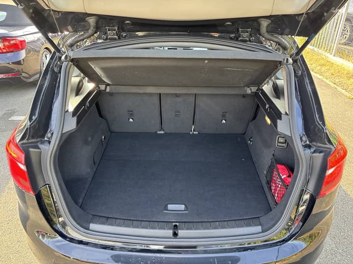 Slika prikazuje otvoreni prtljažnik automobila, fokus na eksterijer.