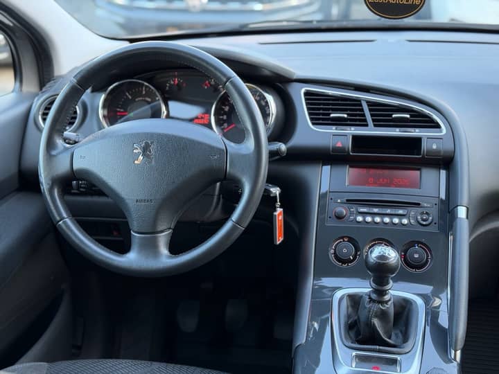 Slika prikazuje unutrašnjost vozila; volan i središnji panel.