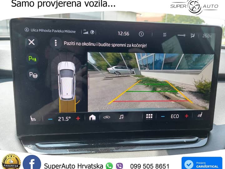 Slika prikazuje unutrašnjost vozila s infotainment zaslonom.