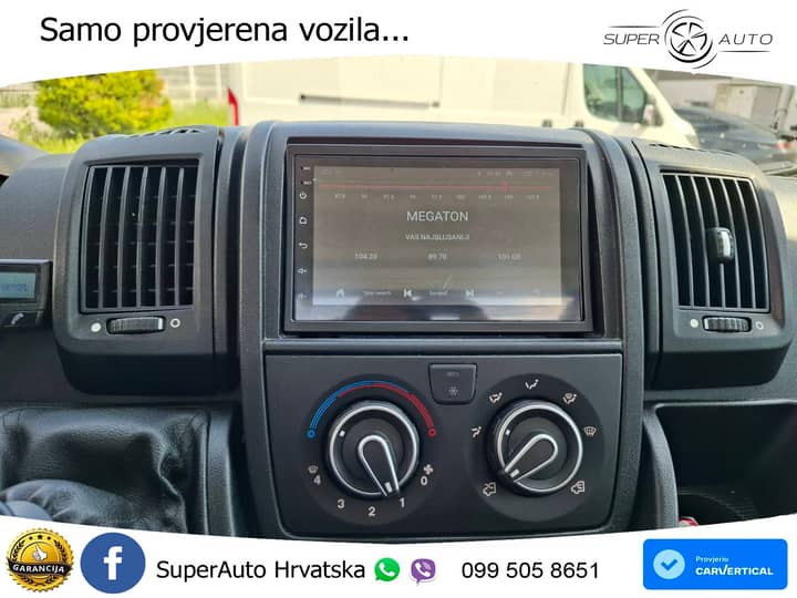 Slika prikazuje unutrašnjost vozila – instrument ploča i kontrole.