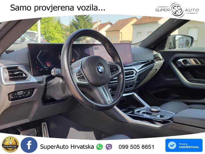 Slika prikazuje unutrašnjost vozila, volan i kokpit.