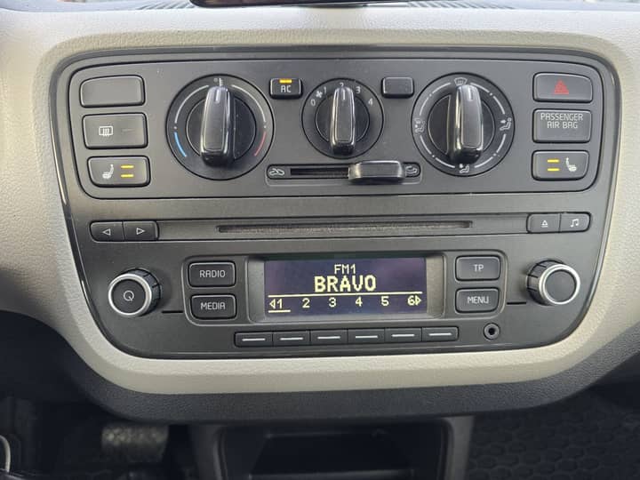 Slika prikazuje unutrašnjost vozila, uključujući kontrolu klime i radio.