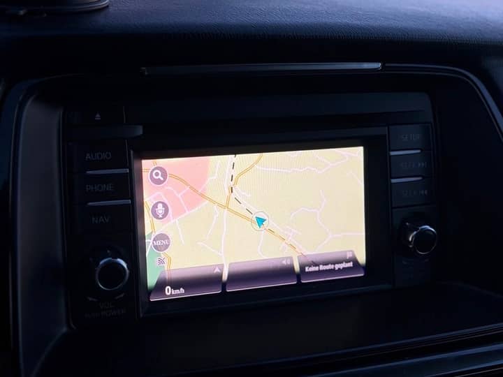Slika prikazuje unutrašnjost vozila, s centralnim zaslonom navigacije.