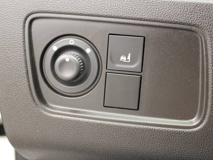 Slika prikazuje unutrašnjost vozila: kontrolni panel i tipke.