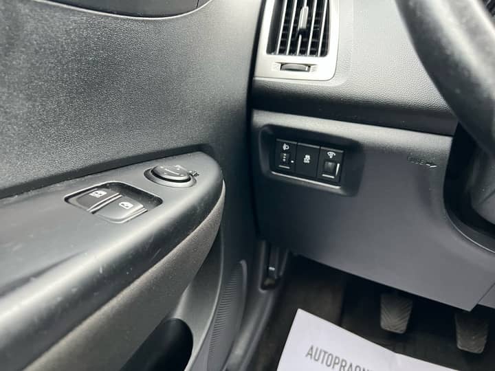 Slika prikazuje unutrašnjost vozila, fokus na upravljač i kontrole.