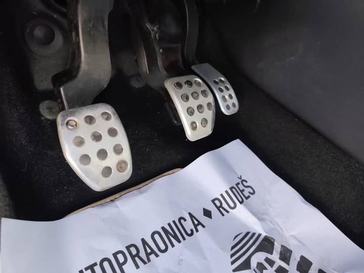 Slika prikazuje unutrašnjost vozila, fokus na pedalama.