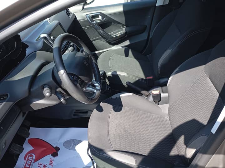 Slika prikazuje unutrašnjost vozila (volan i sjedala).