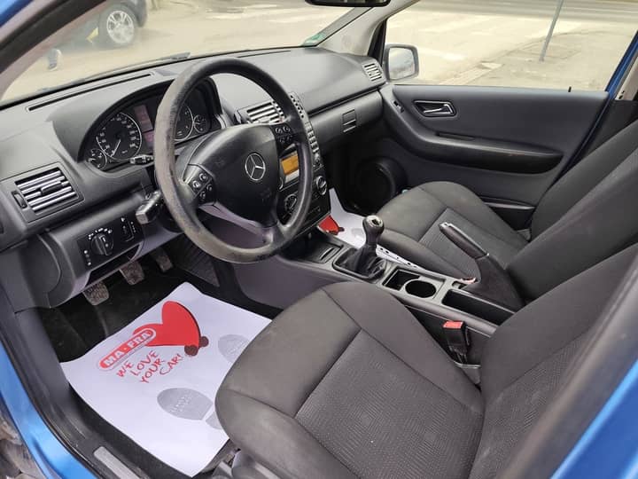 Slika prikazuje unutrašnjost vozila (volan i sjedala).
