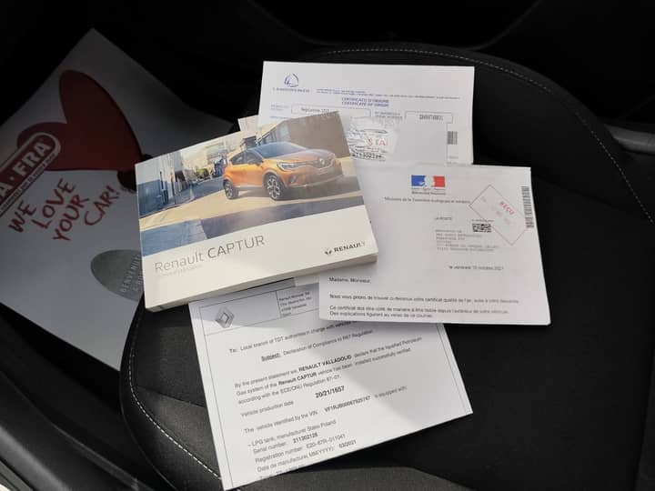 Slika prikazuje unutrašnjost vozila s dokumentima na sjedalu.