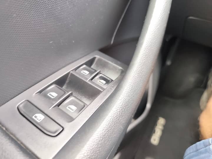 Slika prikazuje unutrašnjost vozila (panel upravljača prozora).