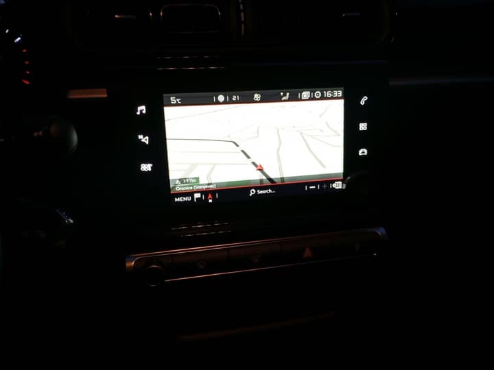 Slika prikazuje unutrašnjost vozila; zaslon navigacije.