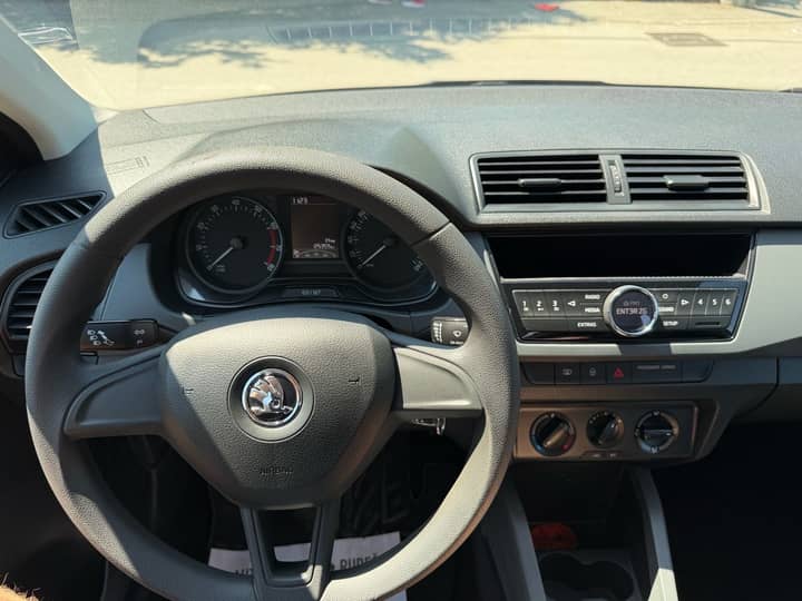 Slika prikazuje unutrašnjost vozila, fokus na volan, instrument ploču i središnju konzolu.