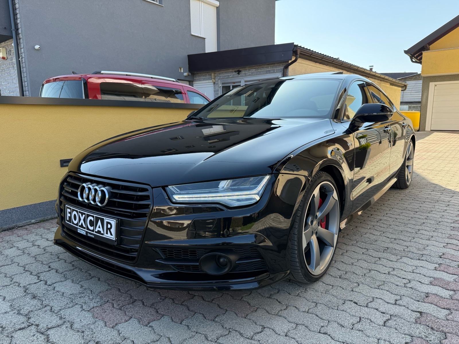 Slika prikazuje vanjštinu vozila (automobil na parkingu).